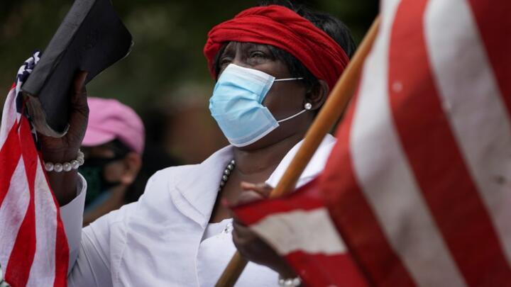 A woman holds an American flag and a Bible outside the funeral for Rayshard Brooks, the Black man shot dead by an Atlanta police officer, at Ebenezer Baptist Church in Atlanta, Georgia, US on June 23, 2020.